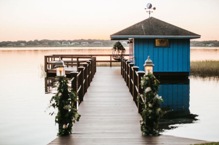 A dock at sunset with flowers wrapped around the end posts
