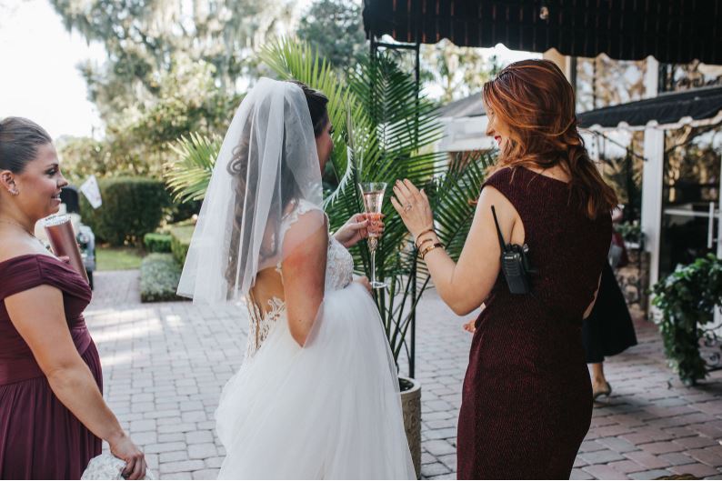 a wedding coordinator serves a bride champagne