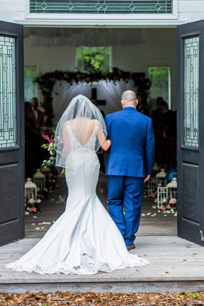 a bride and her father stand at open double doors about to walk down the aisle
songs to walk down the aisle to