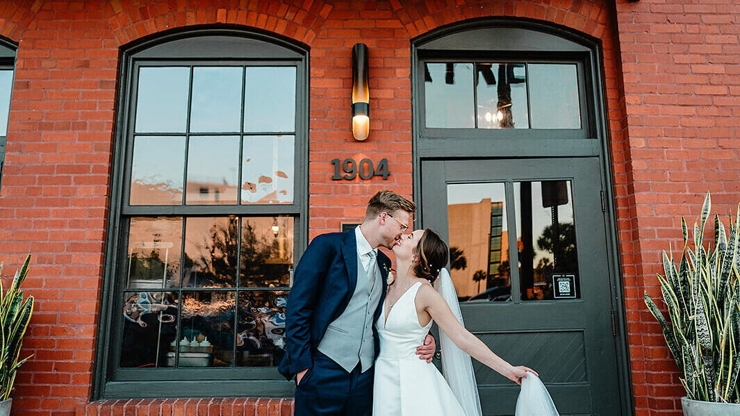 Bride & Groom standing in front of  brick building for the city wedding